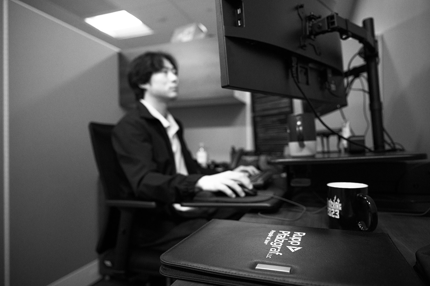 staff member reviewing work on computer screens